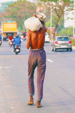 Zavallı Hintli adam sokakta çıplak ayakla yürüyor.