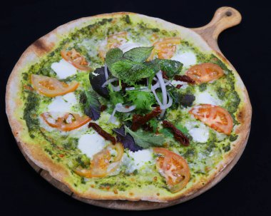 Fesleğen soslu ve domatesli ince hamurlu pizza.