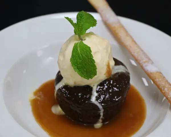 stock image sticky toffee pudding with vanilla ice cream and caramel sauce