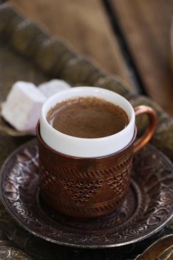 Geleneksel Türk kahvesi bakır bardakta, masanın üstünde.