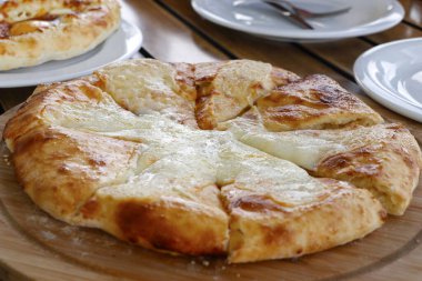 Sofrada imeruli khachapuri tabağı olarak bilinen peynirli geleneksel Gürcistan ekmeği.
