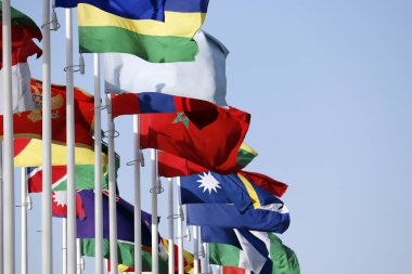 Fuar sırasında mavi gökyüzüne karşı birçok farklı ulusun bayrakları.
