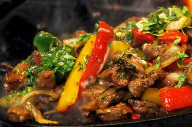 Meksika yemeği tüttüren tavuk ve sığır fajitası sıcak tabakta