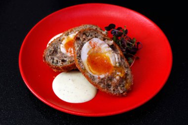 İskoç yumurtası, sosise sarılmış haşlanmış yumurta, ekmek kırıntılarıyla kaplanmış ve kızartılmış.