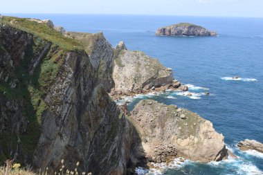 Arka planda bir deniz bulunan kayalık bir uçurumun dikey görüntüsü ASTURIAS ASTURIAS