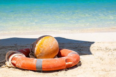 Mavi denizin arka planında, kumlu sahilde dinlenen cankurtaran botu