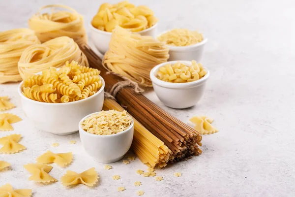 Pasta month. Assortment of uncooked pasta and noodles. Italian food culinary concept. Collection of different raw pasta on cooking table