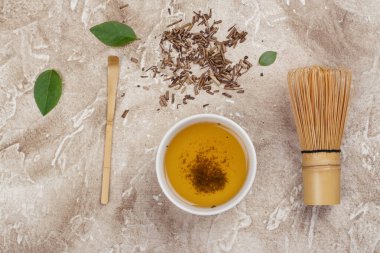 Kuru hojicha yeşil çay yaprakları ve taş bir masada hojicha çayı. Üst görünüm