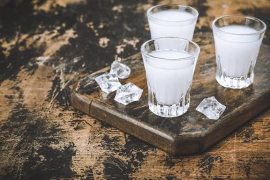 Geleneksel Yunan votkası uzo ve ahşap masa üzerinde marine edilmiş zeytin