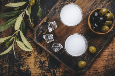 Geleneksel Yunan votkası uzo ve ahşap masa üzerinde marine edilmiş zeytin