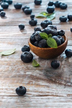 Kırsal masadaki ahşap bir kasede taze yaban mersini. Uluslararası yaban mersini ayı - Temmuz geçmişi. Ahşap arka planda Bilberry. Yabanmersinli antioksidan. Sağlıklı yeme ve beslenme kavramı