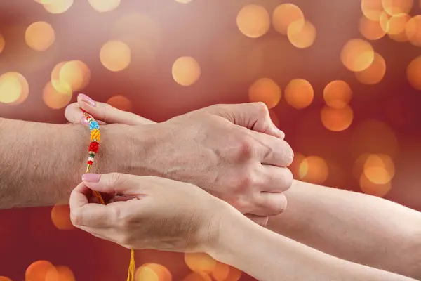 stock image Happy Raksha Bandhan Holiday Background. Indian sister is wearing rakhi bracelet on his indian brother