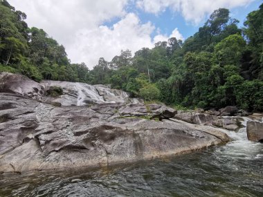 Karome Waterfall, dağdaki güzel şelale mavi gökyüzü ve beyaz kümülüs bulutları. Tropikal yeşil ağaç ormanında şelale. Şelale ormanda akıyor. Khao Luang Milli Parkı 'nda doğal sesler ve doğal güzelliklerle bir yürüyüş. 