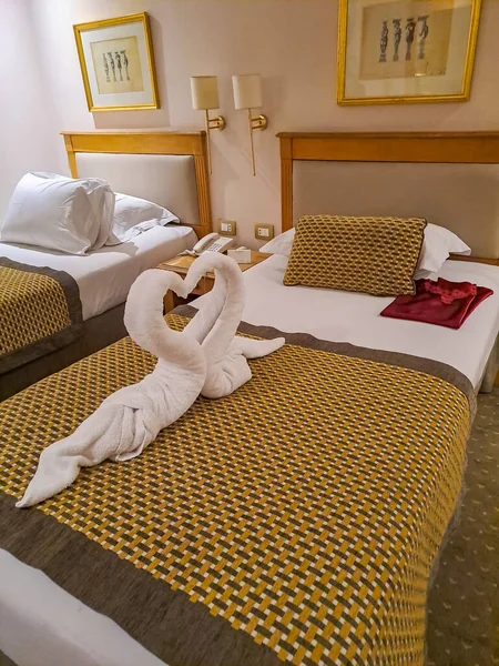 Towel folded in swan shape on bed sheet in bed room. Nile. Egypt. High quality photo