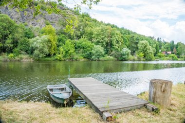 Zadni Treban adası yakınlarındaki Berunka nehrinin sakin yüzeyinde tahta bir tekne. Çek Cumhuriyeti. Yüksek kalite fotoğraf