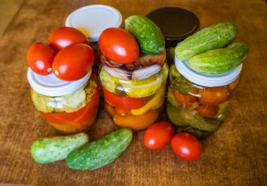 Salatalık turşulu cam kavanozlar, domates turşusu ve lahana. Çeşitli sebze turşusu kavanozları. Kırsal bir kompozisyonda konserve yiyecekler. Yüksek kalite fotoğraf