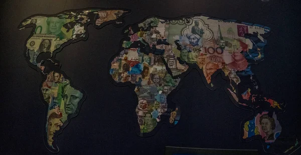 World map with continents made from money of different countries on black background. High quality photo