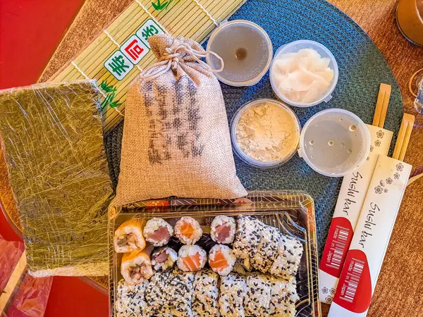Everything you need to create sushi. Rice, nuri sheets, ginger, soy sauce, wasabi and vinegar on sushi and of course a bamboo mat. Rainbow sushi roll, uramaki, hosomaki and nigiri. High quality photo