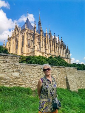 St. Barbara Kilisesi 'nin mavi gökyüzü altında manzaralı bulutlarla gezen son sınıf öğrencisi kadın, Kutna Hora, Çek Cumhuriyeti. UNESCO Dünya Mirası sitesi. Yüksek kalite fotoğraf
