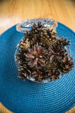 Ahşap masa üzerinde çam kozalakları olan güzel kristal kase, çok dekoratif ve sonbahar, kış ve Noel 'de kullanılır. Yüksek kalite fotoğraf