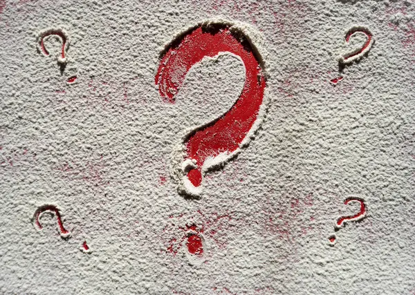 Drawn question mark on red background, drawn on flour. Question mark, surprise, or question. High quality photo