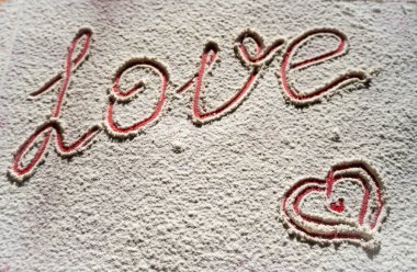 Un üzerine kırmızı bir yazı, aşk ve boyalı bir kalple yazılmış bir resim. Romantik aşk Sevgililer Günü tatili konsepti. Yüksek kalite fotoğraf