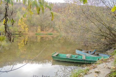 Berounka nehrinin güzel manzarası ve sonbahar mevsiminde iki tahta tekne, orman ve dağlar, Hlasna Treban. Çek Cumhuriyeti 'nden. Yüksek kalite fotoğraf