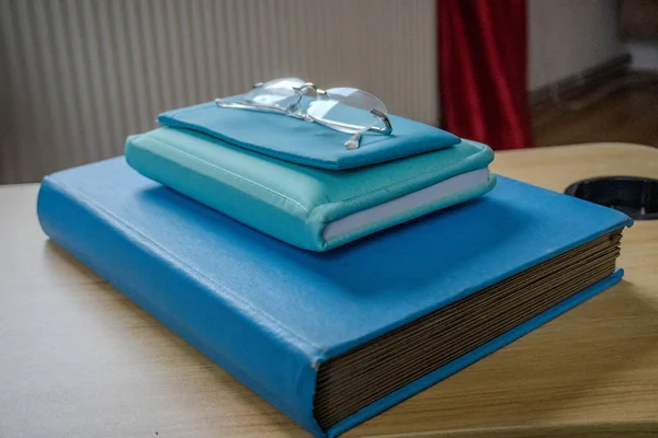 Blue Monday. A book, a notebook and a case with glasses, all in blue tones. The most depressing day of the year. The day of commit suicide and depression. High quality photo
