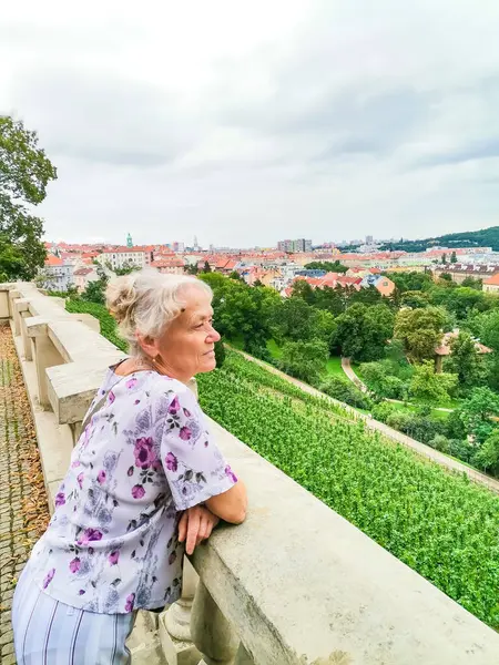 Prag 'ın güzel arka planında turist olan kadın. Prag 'da gezintiye çıkmış yaşlı bir kadın. Yüksek kalite fotoğraf