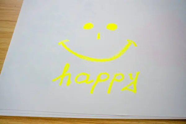 Beyaz arka planda sarı, mutlu bir gülümseme. Üzerinde Happy yazılıydı. İyimserlik ve olumlu düşünce anlayışı. Beyaz arka planda izole edilmiş sarı bir ifade. Yüksek kalite fotoğraf