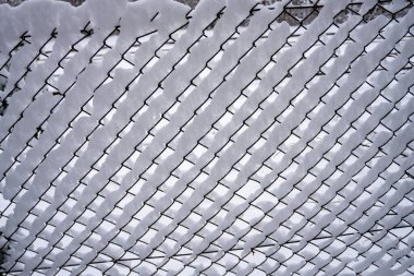 Orta Batı 'da Kış Harikalar Diyarı. Eskrim ağındaki kar dokusu. Kışın karla kaplı metal tel örgüler. Yüksek kalite fotoğraf