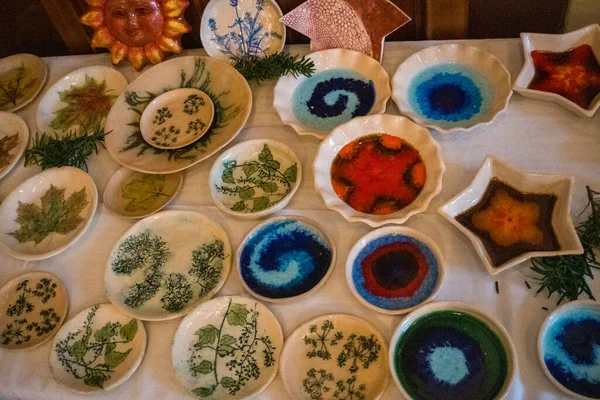 Manual labor. Colorful ceramic plates sold outdoors, in front of a souvenir shop in the village. Czech. High quality photo