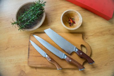 Biberiye yaprakları mutfakta ahşap bir tabakta, doğranmaya hazır Şam çelik bıçaklarının yanında. Yüksek kalite fotoğraf