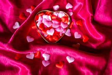 Kırmızı ipek arka planda birçok kırmızı kalbi pembeye boyayıp kapatıyoruz. Sevgililer günü tasarımın kutlu olsun. Aşk metni ve kalbinle. Yüksek kalite fotoğraf