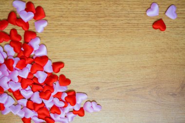 Üst manzara ve kapatma birçok kırmızı kalp ahşap bir arka planda pembe. Sevgililer günü tasarımın kutlu olsun. Aşk metni ve kalbinle. Yüksek kalite fotoğraf