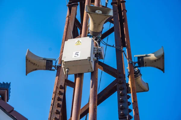 Electrical box on a concrete pole in the village, against the blue sky. With speakers for news or sirens.Selective focus.Electrical equipment for the distribution of energy. Industrial Landscape
