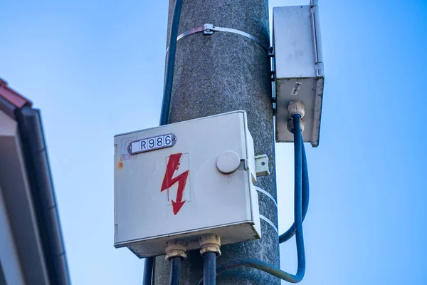 Electrical box on a concrete pole in the village, against the blue sky. Selective focus.Electrical equipment for the distribution of energy. Close-up. Industrial Landscape. High quality photo