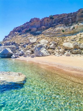 Rodos 'ta deniz ve ada manzaralı bir kayanın üzerinde otlayan Yunan keçisi. Yüksek kalite fotoğraf