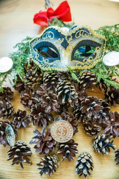 Christmas and New Years decor. Decorative fir-tree with silver decoration and festive brilliant mask on wooden background, concept of New Years holiday,close-up, copy space. High quality photo