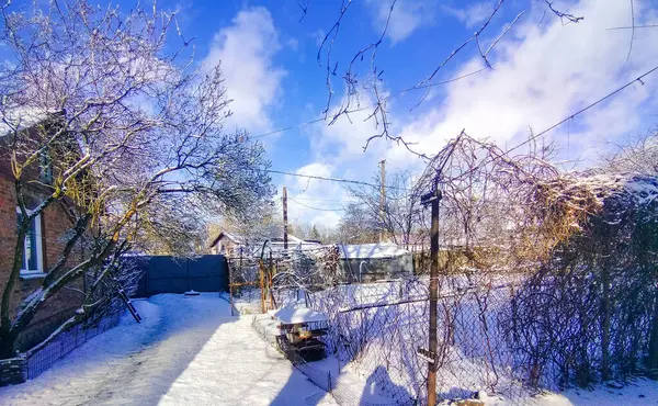 Yard and house covered with snow in the Korop. Winter landscape in the Ukrainian village with sun snd sky. High quality photo