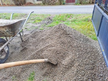 Büyük gri moloz yığını, bir kürek ve yol enkazında küçük taşlar. Yüksek kalite fotoğraf