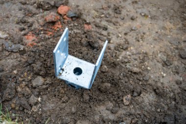 İnşaat alanındaki ahşap bir sütuna vidayla demir desteği. Teras için tahta sütunlar. Yüksek kalite fotoğraf