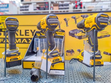 Üzerine ışık düşen çapraz şekilli bir sopayla kablosuz elektrik tornavidasının yatay görüntüsü. Bir marangozluğun arka planında. Yüksek kalite fotoğraf