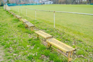 Sabah futbol sahasının yanında ahşap bir bankta. Baharın başında. Yüksek kalite fotoğraf