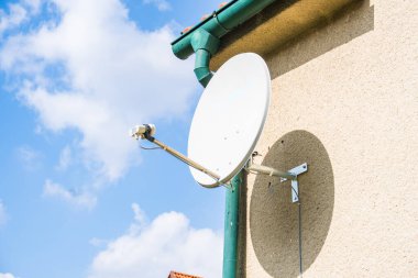 uydu antenleri ve TV antenleri evin çatısında mavi gökyüzü arkaplanlı. Tasarım veya metin için kopyalama alanı olan anteni kapat. Yüksek kalite fotoğraf