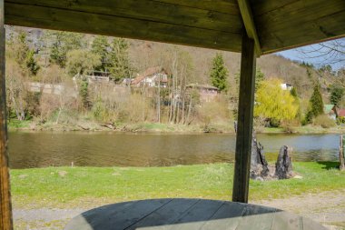 Nehir kenarında piknik için bir yer. Tahta çardak ve Berunka Nehri yakınlarındaki ahşap köprü. Çek malı. Yüksek kalite fotoğraf