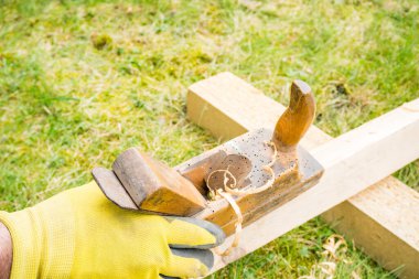 Yatay, yüksek açılı, küçük, klasik ahşap planörlü bir stüdyo çekimi. Üzerinde tahta solucan delikleri olan eski bir marangoz aleti. İnce ahşap talaşı. Marangozluk konsepti. Yüksek kalite fotoğraf