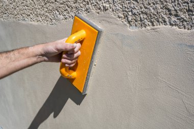 Bir işçi evin dışından bir duvar örüyor. İnşaat konsepti. Yüksek kalite fotoğraf