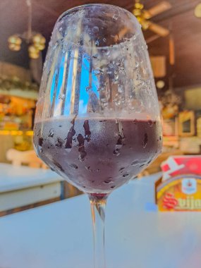 Şişeden şarap bardağına kırmızı şarap dökülüyor. Şarap uzmanı tatma, derecelendirme ve içme şarabı, arka planda şişeler. Kopyalama alanı olan şarap listesi tasarım menüsü. Alkol içecek kartı arkaplanı. kalite fotoğraf