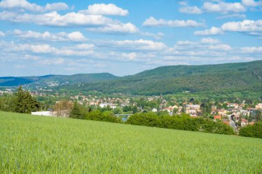 Ufka doğru uzanan yemyeşil buğday mahsullerini yakalayan nefes kesici bir sahne, yüksek, görkemli dağların arka planına kurulur. Revnice, Çek. Yüksek kalite fotoğraf